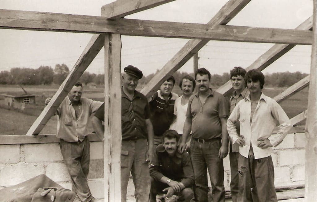 Podczas prac związanych z wykonaniem więźby dachowej na budynku stolarni (Leszek Wójcik – trzeci z prawej), 1986 r.