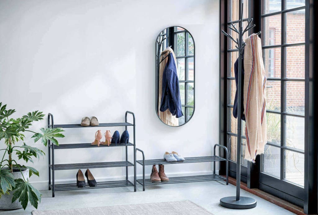 Przedpokój wyposażony meblami z Jysk, m.in. regałami na buty „Hals 2”, „Hals 4”, metalowy stojak na ubrania „Vammen”, wieszak „Galsted”.
