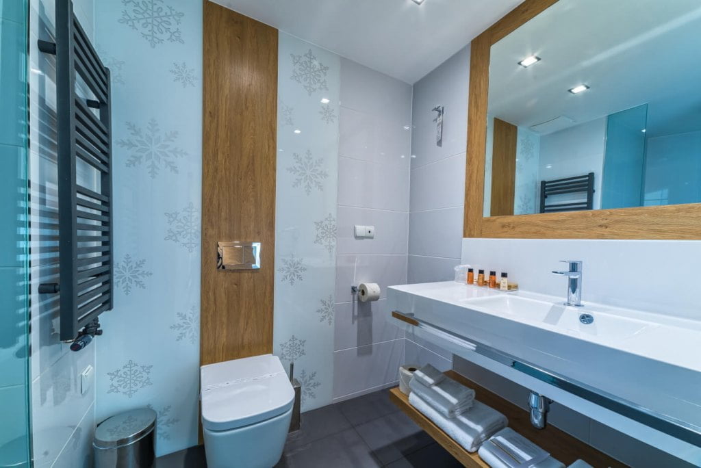 Eksperci z Luxrad podkreślają, że sprawdzonym pomysłem jeśli chodzi o powiększenie łazienki jest lustro. Odbicie lustrzane może sprawić, że łazienka stanie się znacznie większa. Warto wybrać duże lustro nad umywalkę.