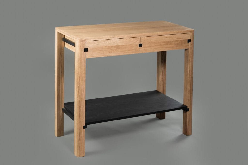 Camino to wyjątkowa konsola, proj. Ewy Półtorak dla marki borcas. Nowość łączy naturalne piękno drewna z nowoczesnym minimalizmem. Doskonale sprawdzi się zarówno w jadalni, jak i w innych częściach domu, pełniąc rolę eleganckiego, a jednocześnie praktycznego mebla. Projekt opiera się na precyzyjnym balansie między estetyką a funkcjonalnością. Listewki umieszczone na górnej części konstrukcji pełnią podwójną rolę – łączą nogi oraz służą jako prowadnice dla szuflad, które zapewniają dodatkową przestrzeń do przechowywania. Dolna półka stabilizuje całość, a jednocześnie może być wykorzystana na dekoracje, książki lub inne akcesoria.