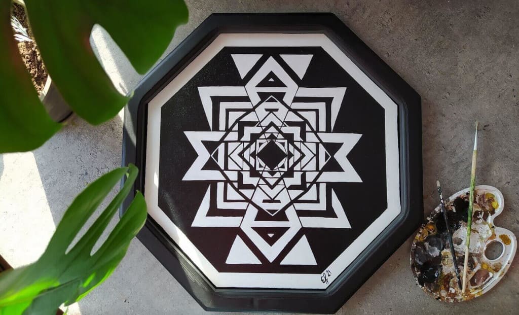 Uszkodzone lustro w drewnianej ramie. Po przemalowaniu powstał etniczny obraz.