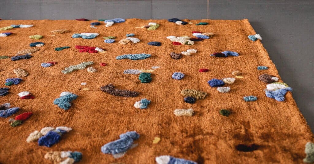 Dywan „Chaos” (proj. Audrone Drungilaite) powstał z przędzy będącej odpadem z produkcji dywanów. Dywany produkuje firma rodzinna Emko z Poniewieża (Litwa).