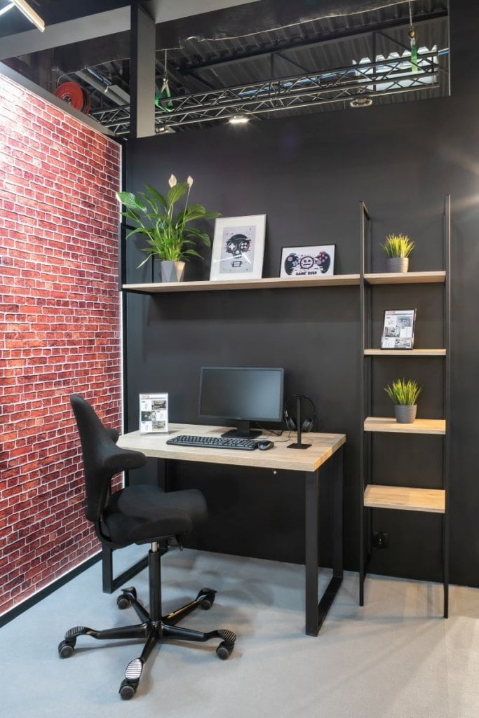 Przestrzeń loftowa na bazie metalowych stelaży Profil System firmy GAMET: biurko na solidnych czarnych nogach, regały na bazie stelaży, stojak na słuchawki oraz listwa na przewody montowana do blatu w tylnej części biurka  - miesięcznik i portal informacyjny branży meblarskiej biznes.meble.pl