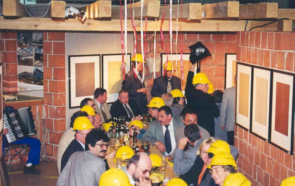 Rok 1998 r. i montaż stoiska Schattdecor. Po zawieszeniu wiechy rozpoczęło się tradycyjne, budowlane świętowanie tego jakże ważnego wydarzenia. Były śpiewy przy akompaniamencie akordeonu, uginające się od jedzenia stoły, a także wspaniała atmosfera, wspierana budowlanymi trunkami.