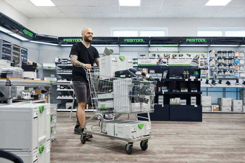 Uśmiechnięty pan z wózkiem na zakupu w sklepie z narzędziamy Festool robi zakupy - miesięcznik i portal informacyjny branży meblarskiej biznes.meble.pl