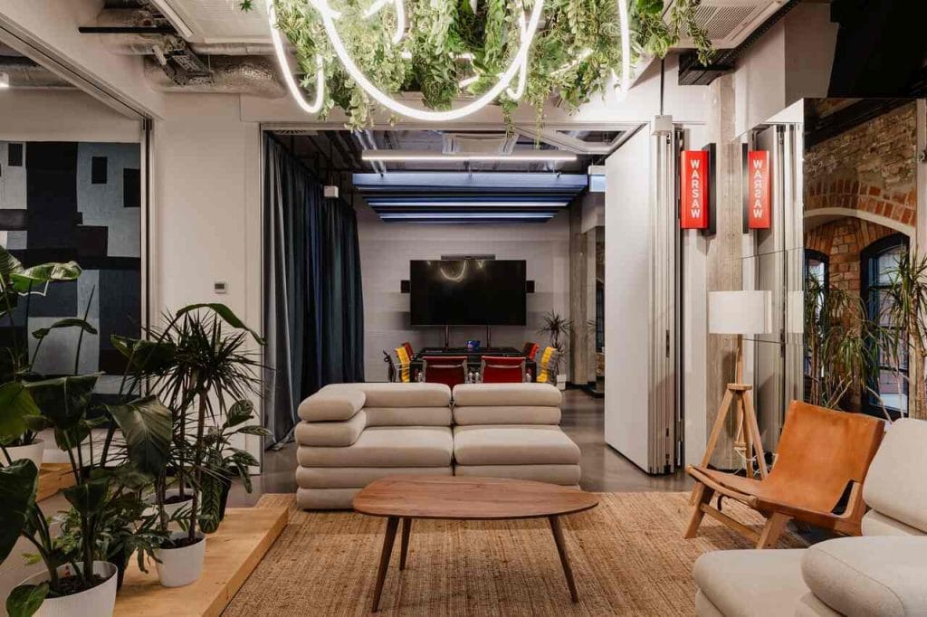 W biurze Levi’s® ekologia nie jest kompromisem, lecz podstawą całej koncepcji. Projektanci Archiworks wykorzystali istniejące zasoby, aby zmniejszyć ślad węglowy, nadając drugie życie wielu elementom. Kanapa w strefie wejściowej pochodzi z Pico the Finder – butiku specjalizującego się w odnawianych meblach designerskich. Sufit akustyczny wykonano z ekologicznych płyt wiórowych z wełny drzewnej, które skutecznie tłumią dźwięki, zachowując jednocześnie lekkość i estetykę. Fot. Zasoby Studio.