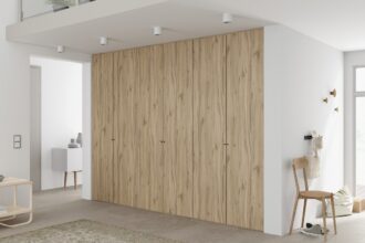 Dekor Justus firmy Interprint w kolorze jasnego drewna pokazany na szafie w białym we wnętrzu - miesięcznik i portal informacyjny branży meblarskiej biznes.meble.pl