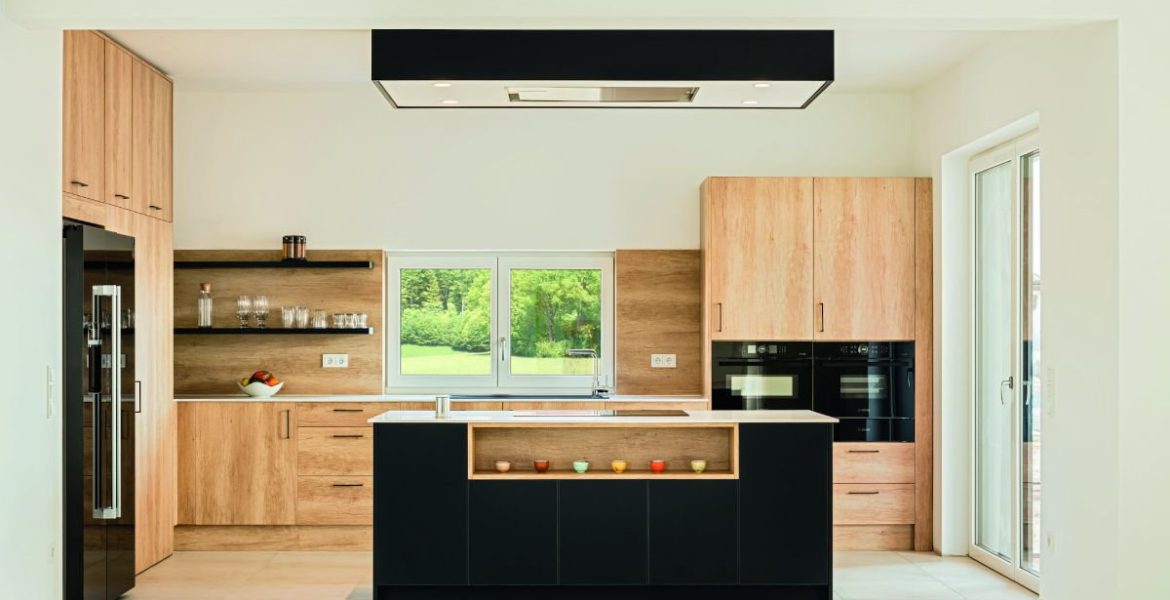 Jasna kuchnia z motywem drewna oraz czerni z blatami roboczymi Egger