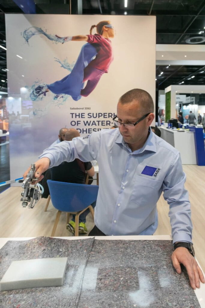 SABA stoisko Interzum 2023, Pan nakładający klej - miesięcznik i portal informacyjny branży meblarskiej biznes.meble.pl