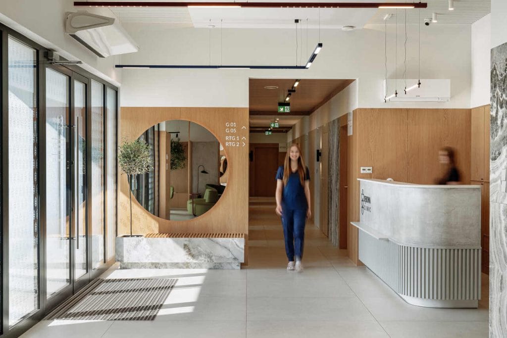 Projektując Dębowa Clinic w Kwidzynie, architekci z MAKA STUDIO zredefiniowali wyobrażenie o przestrzeni medycznej. W nowoczesnych, ale przyjaznych wnętrzach dominują drewno, kojąca zieleń i światło, które zamiast onieśmielać – otula. Klinika przypomina bardziej butikowy hotel niż miejsce leczenia, a za tą transformacją stoi przemyślany projekt, w którym każdy detal ma znaczenie. Fot. Tom Kurek.