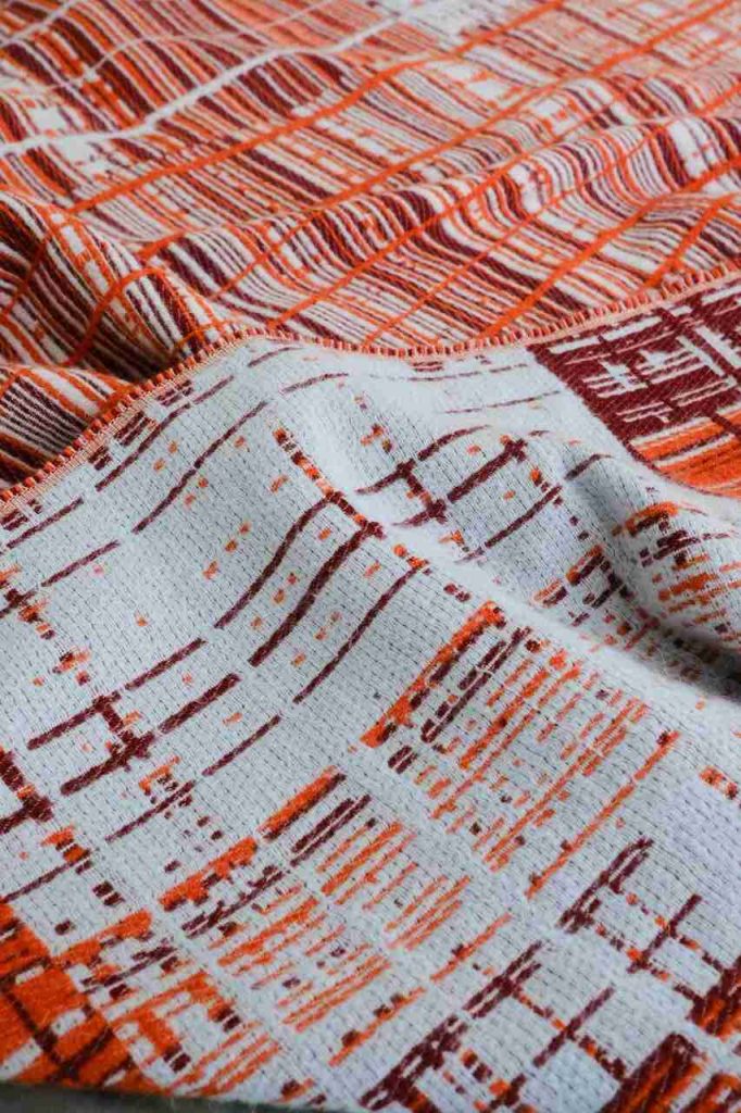 Centralne miejsce zajmują tkaniny z nieregularnym barwieniem, widocznymi szwami i asymetrycznymi wykończeniami. Materiały te nie ukrywają kunsztu, lecz go podkreślają – stanowiąc celowy kontrapunkt dla nieskazitelnej perfekcji projektowania wspomaganego sztuczną inteligencją. Na zdjęciu projekt, który zrealizowała Emma Terweduwe, BeyondBold, Sunset coll GRID II. Fot. ETerweduwe. Źródło: Heimtextil.