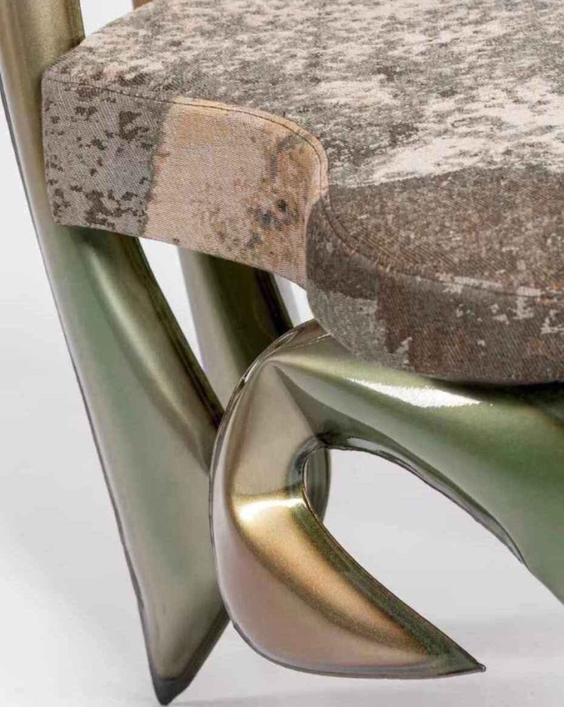 Krzesło Scylla i Charybda od Made by ASTRONAUTS x SERAPIS: stal malowana proszkowo, stal nierdzewna, żywica, tapicerka Rust z recyklingowanej bawełny żakardowej SERAPIS. Zdjęcie dzięki uprzejmości Made by ASTRONAUTS. Źródło: Heimtextil.