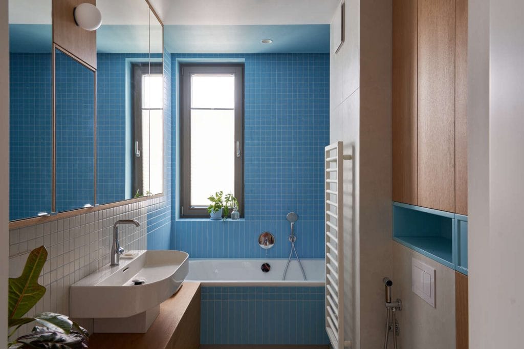 Raspberry Fields  łazienka w apartamencie w Gdańsku. Kolor w roli głównej, mozaika i drewno jako ukłon do stylistyki mid-century. Bez uszczerbku na funkcjonalności – pojemne szafy mieszczą pralkę i suszarkę.