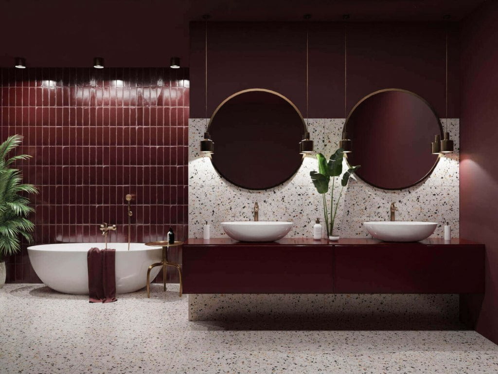 Łazienka w nowoczesnej odsłonie. W tym projekcie wybrano geometryczne, bordowe płytki, umywalki nablatowe, baterie i dodatki w złotym kolorze. Fot. Domni.pl