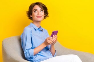 Unity Group, pani z komórką w ręce siedząca na krześle -miesięcznik i portal informacyjny branży meblarskiej biznes.meble.pl