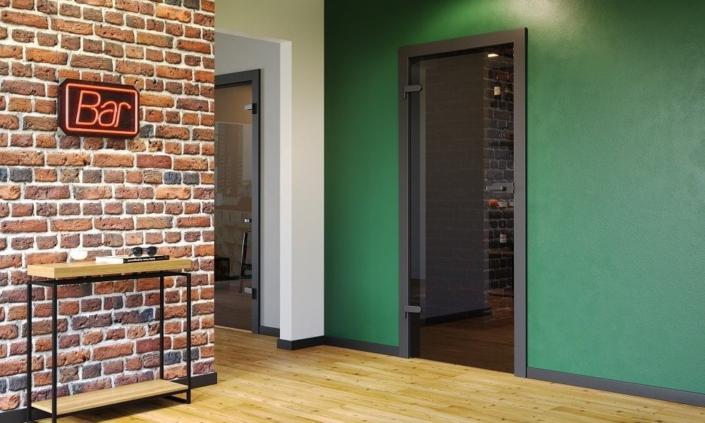 Porta drzwi - drzwi wewnętrzne glass tafla czarna supermatt z czarnymi okuciami na zielonej ścianie - miesięcznik i portal informacyjny branży meblarskiej biznes.meble.pl