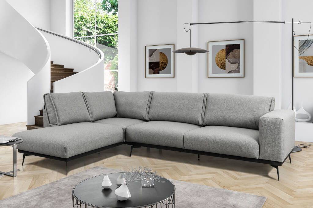 Nowoczesny, wysmakowany i reprezentacyjny narożnik „Tristan” Meble Marzenie. Grube i miękkie poduchy oparciowe zostały wykończone po bokach przeszyciem przypominającym bardzo szerokie lamówki.