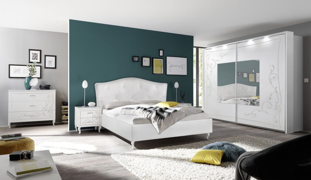 Sypialnia „Gioia” MC Akcent w kolorze białym z nadrukami ozdobnymi. Szafa z drzwiami przesuwnymi, łóżko tapicerowane białą ekoskórą.