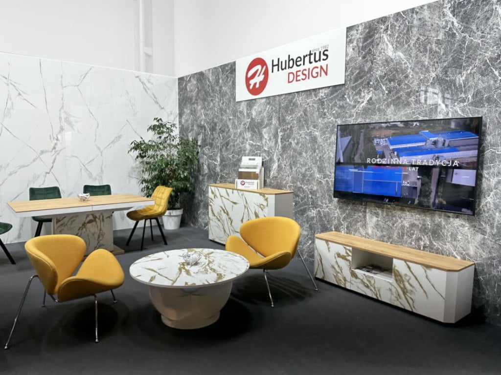 Okrągły stoik i dwa żółte fotele prezentowane na stoisku firmy Hubertus Design podczas targów Meble Polska 2023 w Poznaniu - miesięcznik i portal informacyjny branży meblarskiej