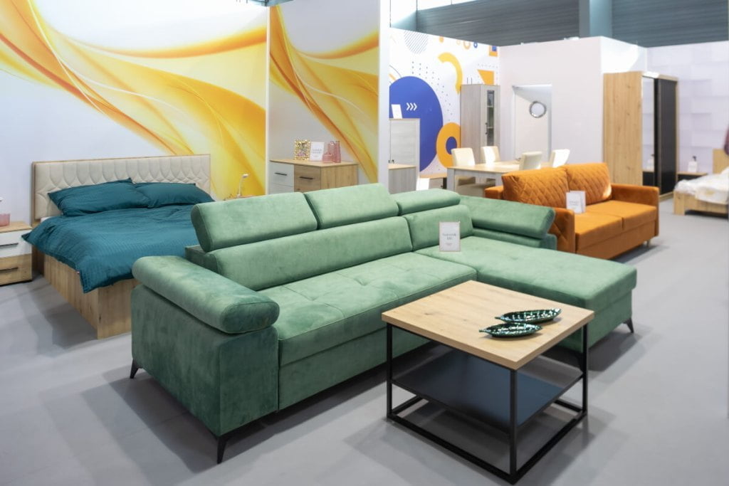 Narożnik Idri w zielonym kolorze oraz stolik kawowy zaprezentowane na stoisku firmy Idźczak Meble na targach Meble Polska 2023 w Poznaniu - miesięcznik i portal informacyjny branży meblarskiej biznes.meble.pl