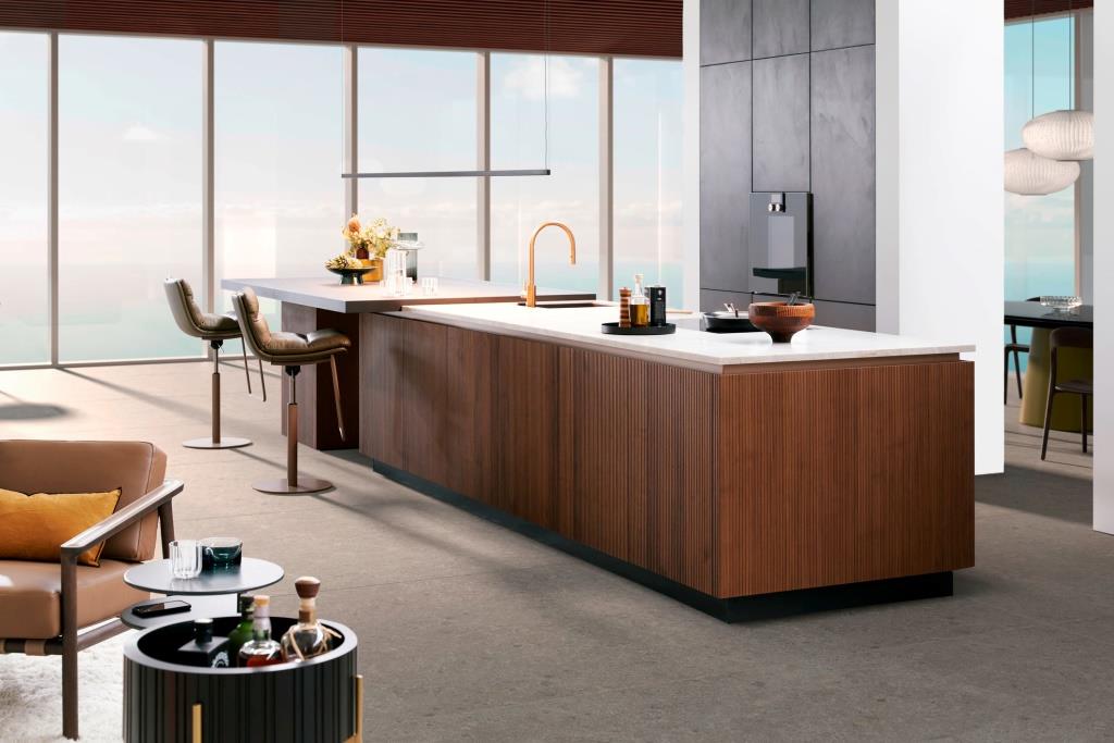 Pionowe żłobienia nadają drewnianym frontom ponadczasowy charakter. Pasuje do nich blat z kamienia naturalnego.