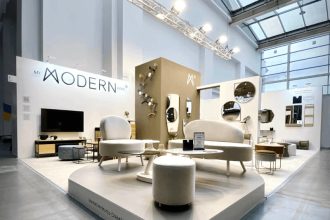 Stoisko My Modern Home na targach Meble Polska 2023, wieszaki na ubrania w różnych kolorach zawieszone na brązowej ścianie - miesięcznik i portal informacyjny branży meblarskiej biznes.meble.pl