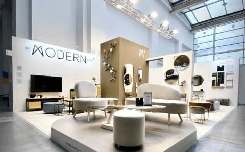 Stoisko My Modern Home na targach Meble Polska 2023, wieszaki na ubrania w różnych kolorach zawieszone na brązowej ścianie - miesięcznik i portal informacyjny branży meblarskiej biznes.meble.pl