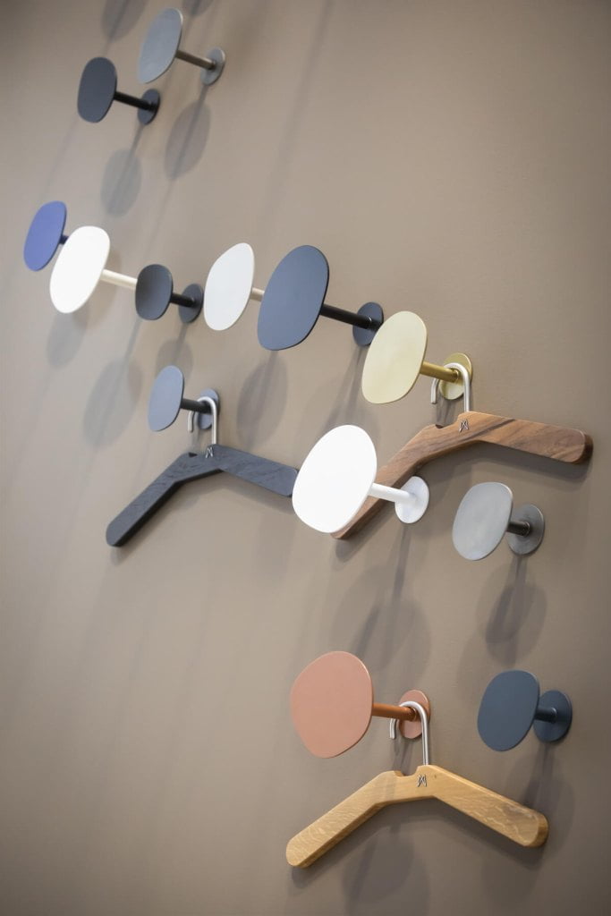 Stoisko My Modern Home na targach Meble Polska 2023, wieszaki na ubrania w różnych kolorach zawieszone na brązowej ścianie - miesięcznik i portal informacyjny branży meblarskiej biznes.meble.pl