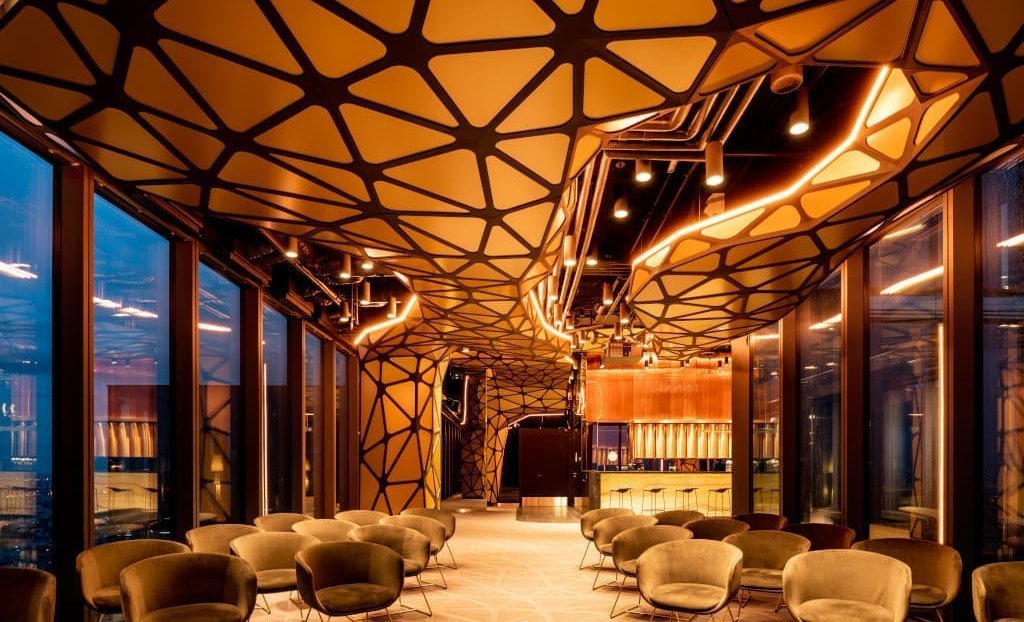 Projekt wnętrz Skyfall. Skyfall to powierzchnia multi funkcyjna zlokalizowana na ostatnim piętrze budynku biurowego Unit w Warszawie. We wnętrzu są punkt widokowy, wychylna platforma widokowa w elewacji, bar itd. Proj. Przemysław Mac Stopa.