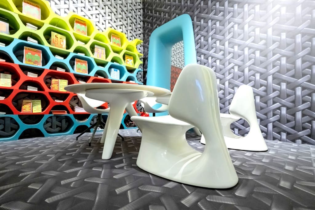 Projekt biura prasowego wydawnictwa Interni w Mediolanie z września roku 2021: organiczne krzesła i stoliki (proj. Przemysław Mac Stopa), wykonane przez TMK Projekt na tle korowego modularnego regału.