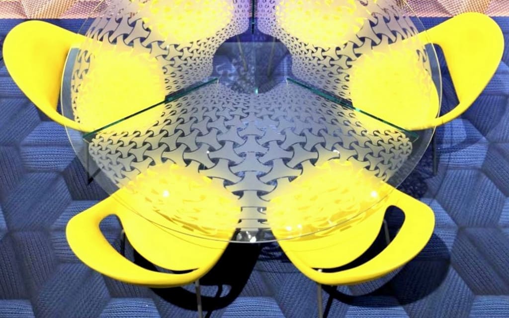 Szklany stół projektu Przemysława Mac Stopy, wykonany we współpracy z włoską firmą OmniDecor. Stół otoczony jest żółtymi krzesłami z kolekcji Moon, zaprojektowanymi dla Tonon Italia.