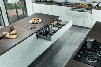 Otwarta szuflada na prowadnicach F70 firmy Salice w białej kuchni z brązowym blatem - miesięcznik i portal informacyjny branży meblarskiej biznes.meble.pl