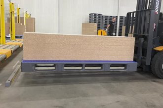 Płyty meblowe na palecie z tworzywa sztucznego (w kolorze niebieskim) z oferty niemieckiej Grupy Craemer na wózku widłowym - miesięcznik i portal informacyjny branży meblarskiej biznes.meble.pl