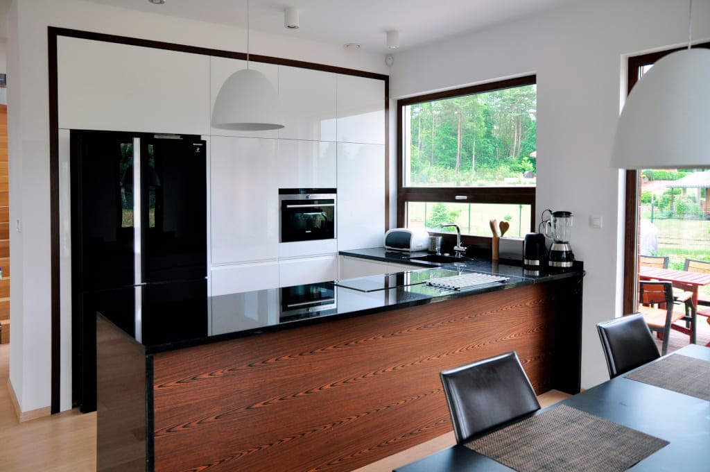 Jedna z realizacji firmy Ekpol. Znakiem rozpoznawczym w tej nowoczesnej kuchni jest duża funkcjonalna wyspa. Całość wieńczy naturalny kamienny blat.