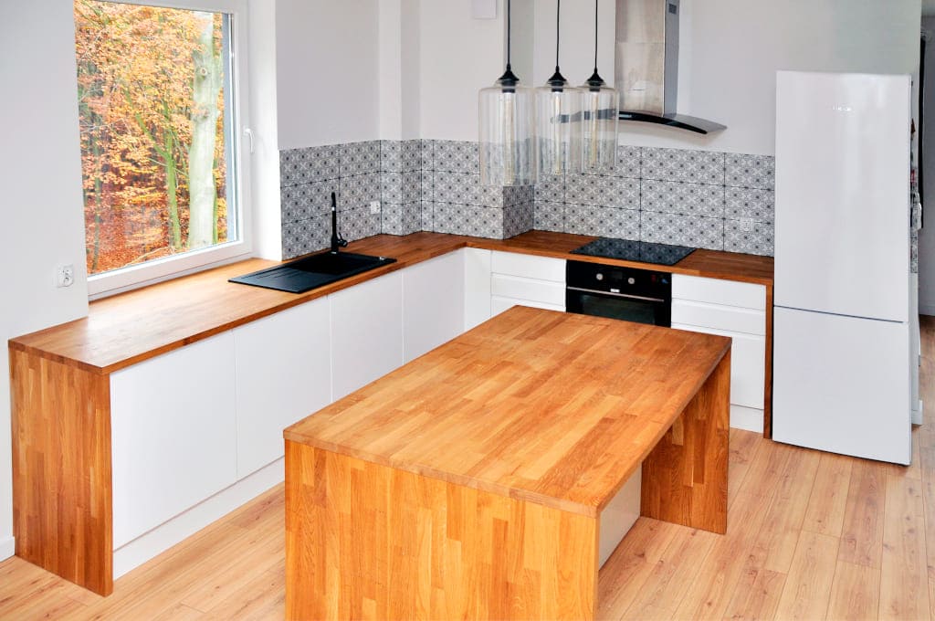 Jedna z realizacji firmy Ekpol. Ta piękna, jasna i słoneczna kuchnia z naturalnym drewnianym blatem i ceramicznymi kaflami.