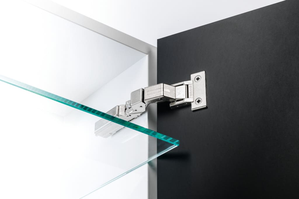 Firma Grass, należąca do grupy Würth, wprowadziła nową linię zawiasów umożliwiających stosowanie nietypowych frontów. Najnowszym zawiasem z tej linii jest „Tiomos M0”, czyli zawias bezpuszkowy.