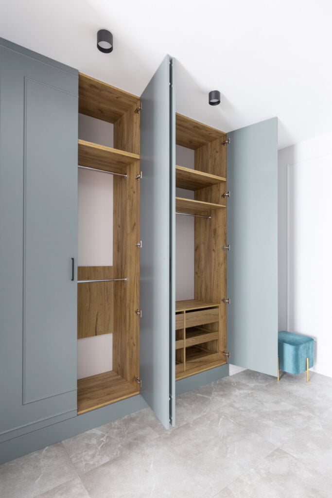 Szafa drewniana z niebieskimi elementami. Dekory Pfleiderer użyte w aranżacji: HDF lakierowany R20475 S Dąb Bijoux Ciemny II, Płyta laminowana Dąb Bijoux R20425 RU.