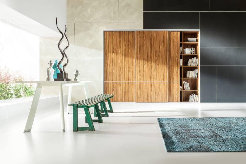 Tradycjonaliści, jako wypełnienie skrzydeł drzwiowych systemu „Heliodor” firmy Komandor mogą wybrać klasyczne płyty meblowe z drewnianym motywem oraz połączyć je z jednobarwnym szkłem.