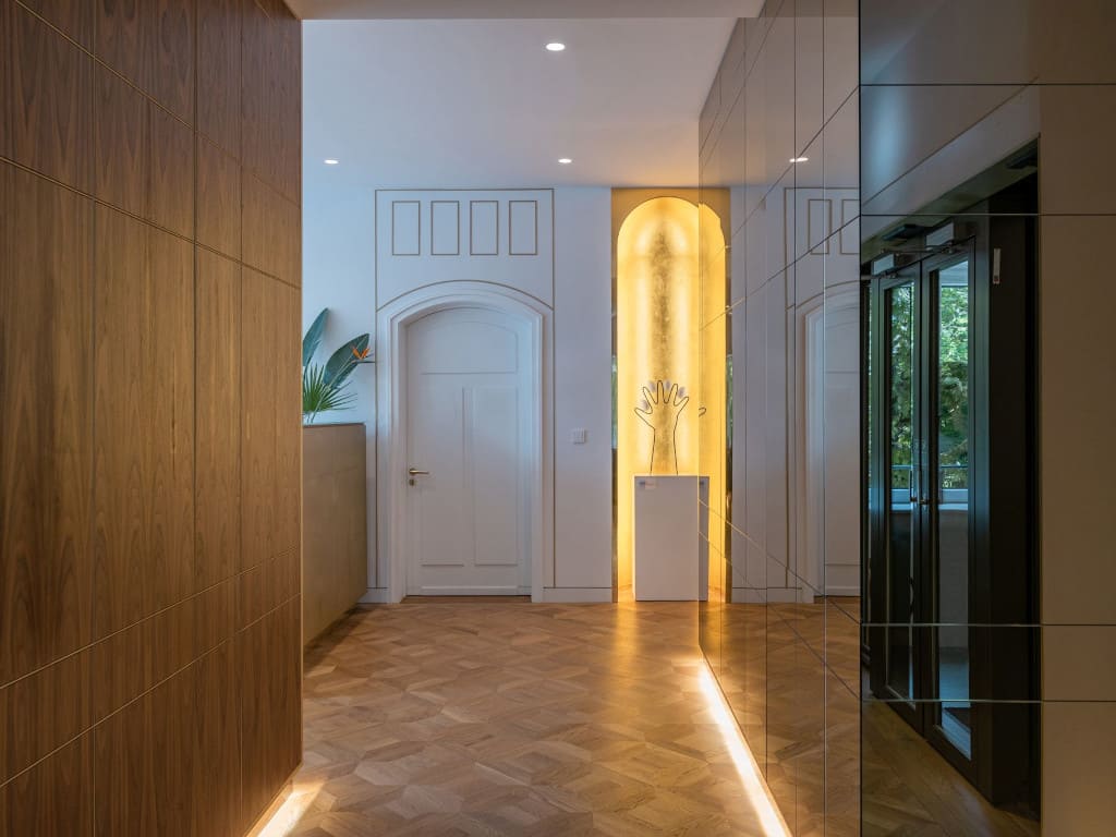 Istniejące elementy dekoracyjne, takie jak zastane na ścianach i sufitach dekoracyjne gzymsy, architekci z pracowni Boris Kudlicka with Partners podkreślili za pomocą oświetlenia i kontrastujących kolorów mebli.