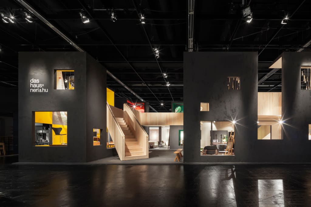 Monumentalna ciemnografitowa fasada z różnej wielkości oknami, przez które przebijają się kolory symbolizujące poszczególne wnętrza – to zewnętrzny obraz „Das Haus – Interiors on Stage 2015”.