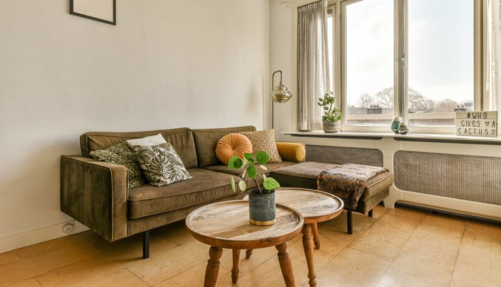 Umeblowany salon, narożnik tapicerowany w brązowej kolorystyce - ile kosztuje umeblowanie mieszkania