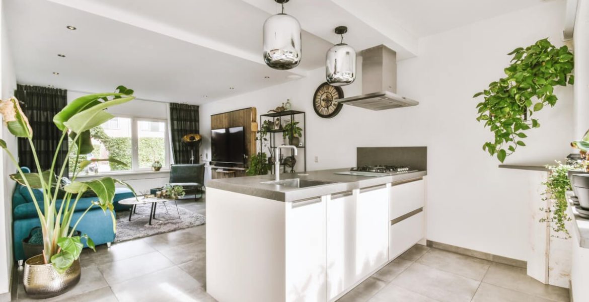 Przestrzeń salonowo-kuchenna z białą kuchnią.