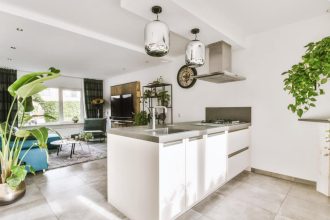 Przestrzeń salonowo-kuchenna z białą kuchnią.