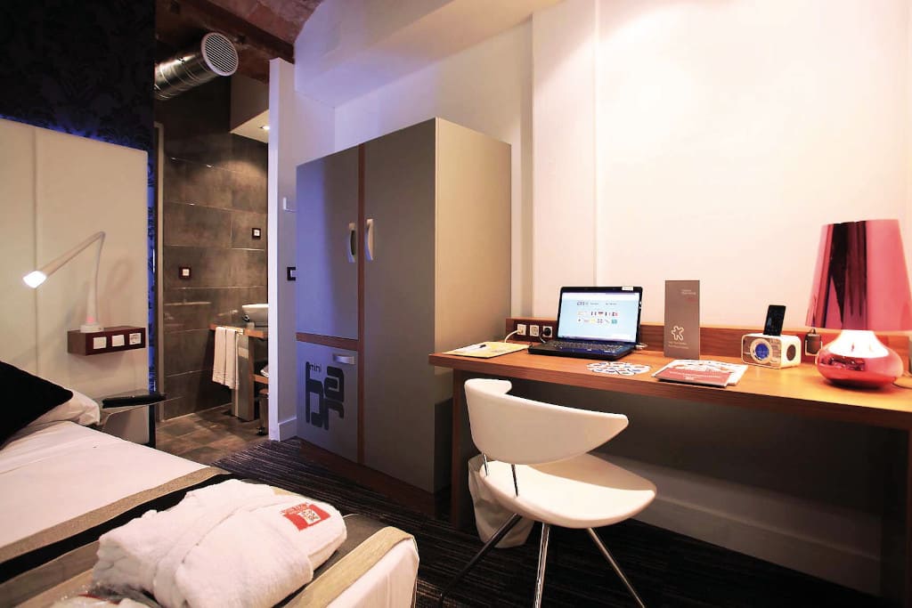 Zestawienie szarości i orzecha cały czas jest bardzo popularne wśród klientów firmy Finsa. Na zdjęciu wnętrze pokoju w hotelu w Barcelonie.