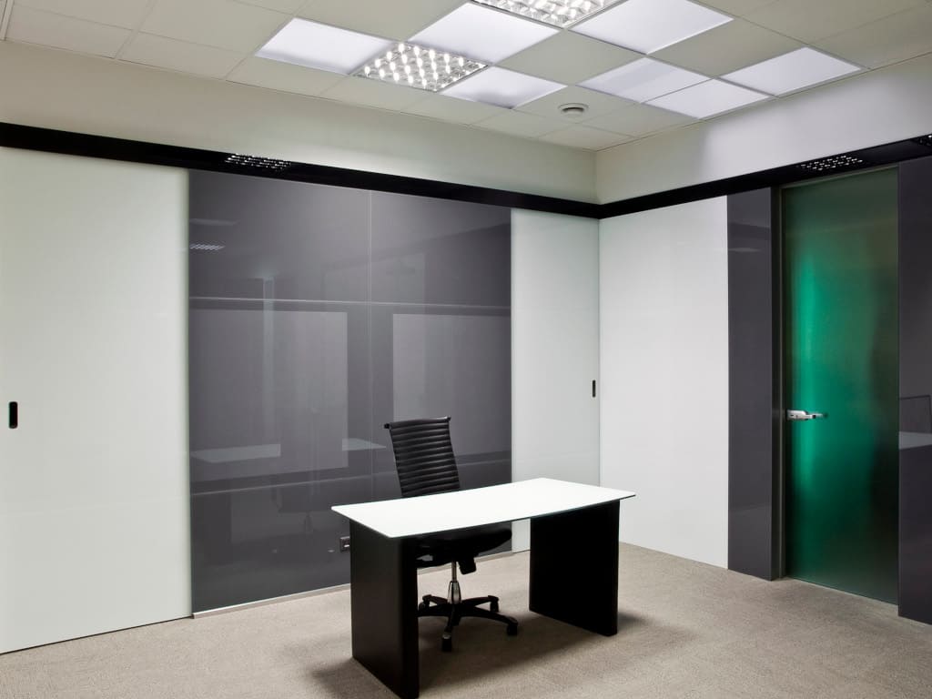 Szkło lakierowane Colorimo o grubości 6 mm na ścianach w biurze. Na szarych panelach dodatkowo naniesiono wzór metodą sitodruku.