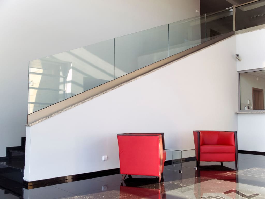 Balustrady szklane firmy M Glass osadzone w kieszeni ze stali nierdzewnej.