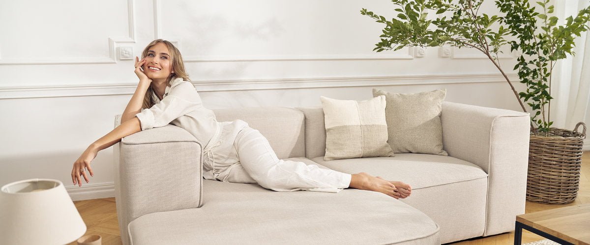 Luss narożnik plecionka z oferty Mononi. Pani w jasnym ubraniu na j jasnym narożniku.