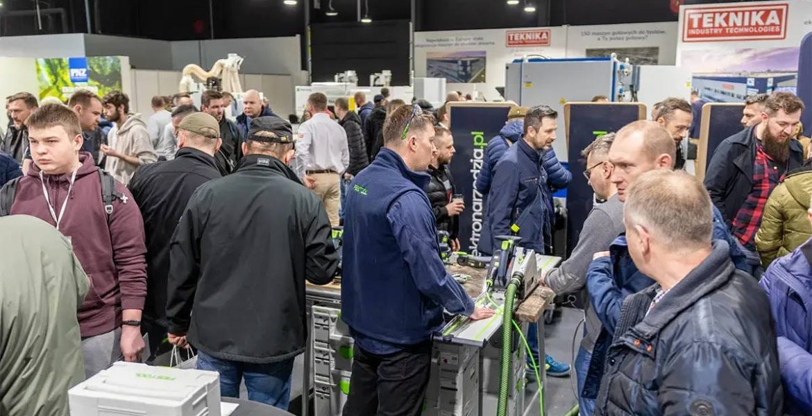 Tłum odwiedzających przy stanowisku z elektronarzędziami na targach branży drzewnej