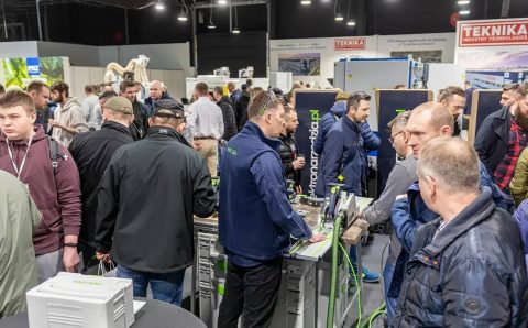 Tłum odwiedzających przy stanowisku z elektronarzędziami na targach branży drzewnej
