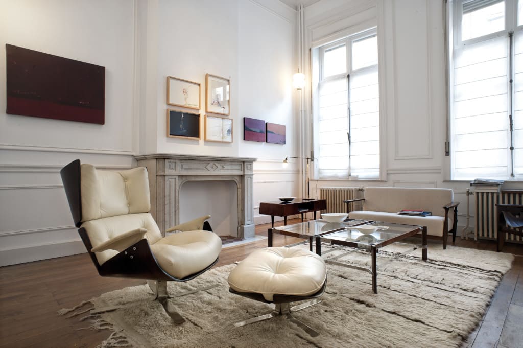 Fotel „Paulista”, wykonany z drzewa jakarandy, skóry i stali, proj. Jorge Zalszupin. W głębi stolik (proj. Jorge Zalszupin i Osvaldo Melone), wykonany z drzewa jakarandy, szkła i metalu.